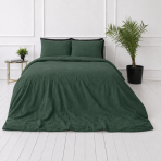 Linne sängkläder „Linen Dark Green“. Påslakanset 150x210, 140x200 cm, 150x200 cm, 160x200 cm, 180x200 cm, 200x200 cm, 200x220 cm, 240x220 cm. Hörnvy av sovrummet: mörkgrön linnefilt och kuddar.